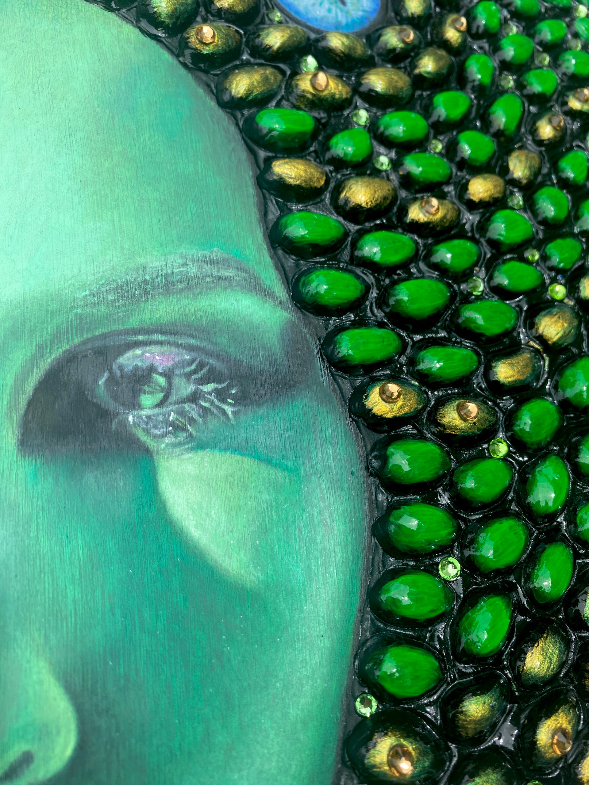 Original mixed media art featuring a self portrait of emerging Los Angeles artist, Shireen Renee as Medusa. The artwork is made from oil paint, acrylic paint, pistachio shells and rhinestones on wood panel. This is a detail image showing the texture of the pistachio shells and the wood panel.
