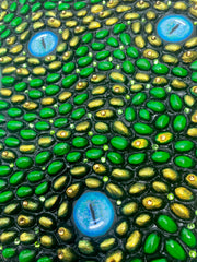 Original mixed media art featuring a self portrait of emerging Los Angeles artist, Shireen Renee as Medusa. The artwork is made from oil paint, acrylic paint, pistachio shells and rhinestones on wood panel. This is a detail image showing the texture of the pistachio shells and the snake eyes painting with oils.