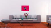 "BAE: Big Art Energy" is an original oil painting by emerging Los Angeles artist Shireen Renee, depicting an eggplant duct taped to a hot pink wall. The image shows the painting in a modern living room hanging on a plan white wall above a gray couch.
