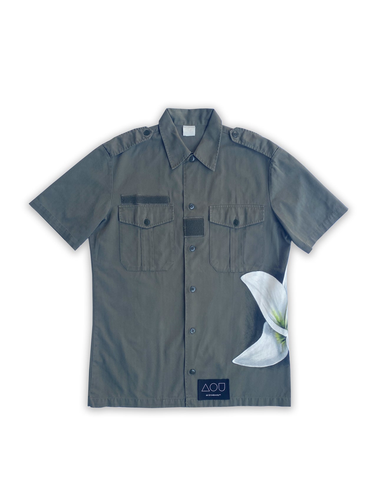 Art of Uniformity French vintage button front army shirt in olive green with a giant hand-painted white lily on the wearer's left side.