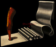 Surreal still life artwork by Shireen Renee, featuring a red and gold ballet slipper piercing a metallic gray, folded chair against a black background. Fine art, surrealism, sculptural art.