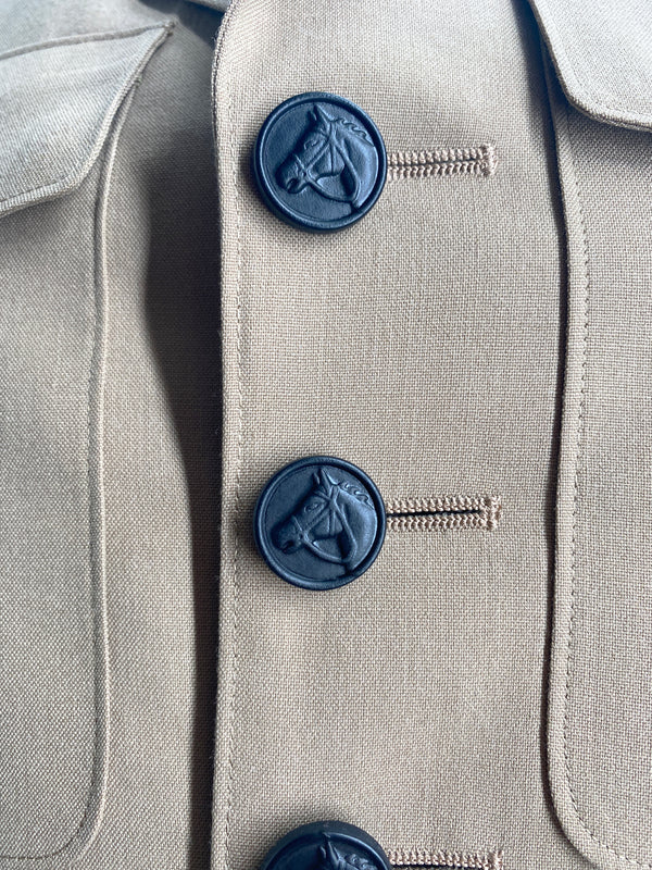 Close up detail of vintage USMC American khaki jacket black buttons with an embossed profile of a horse head.