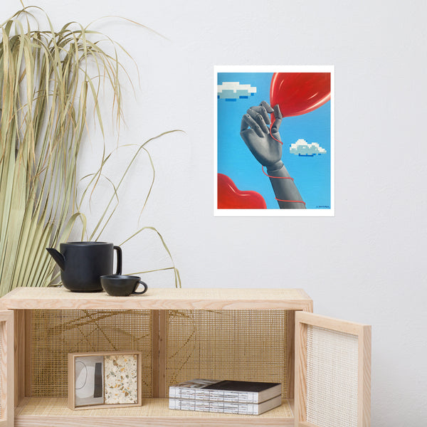 Fine art print of a mannequin hand holding a heart-shaped balloon against a sky blue background with pixelated clouds.