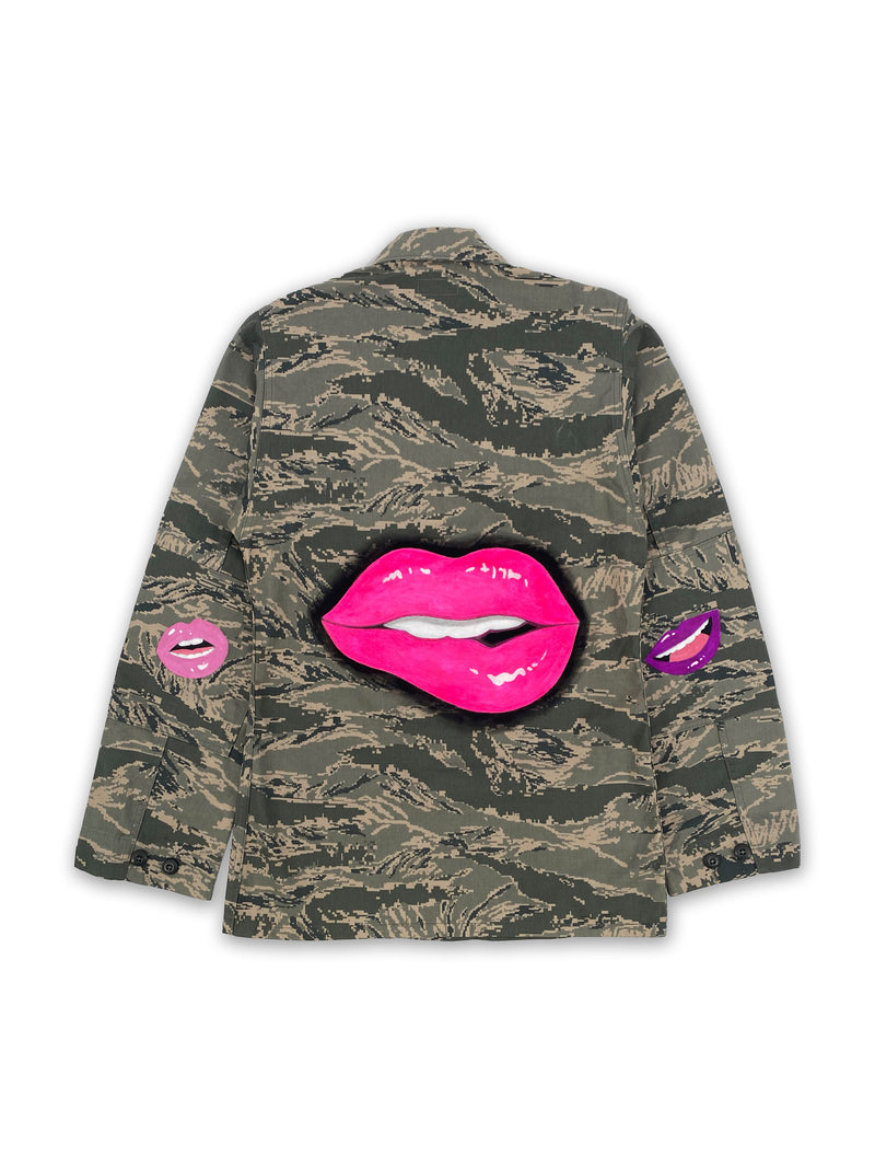 Back view of an American camo jacket with hand-painted pop lip art. Back of garment has giant hot pink cartoon lips with smaller lips on each elbow.