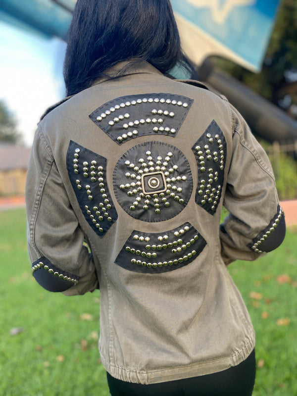 Model wearing a vintage French 80's bomber jacket featuring a studded black leather applique on the back and studded elbow pads.