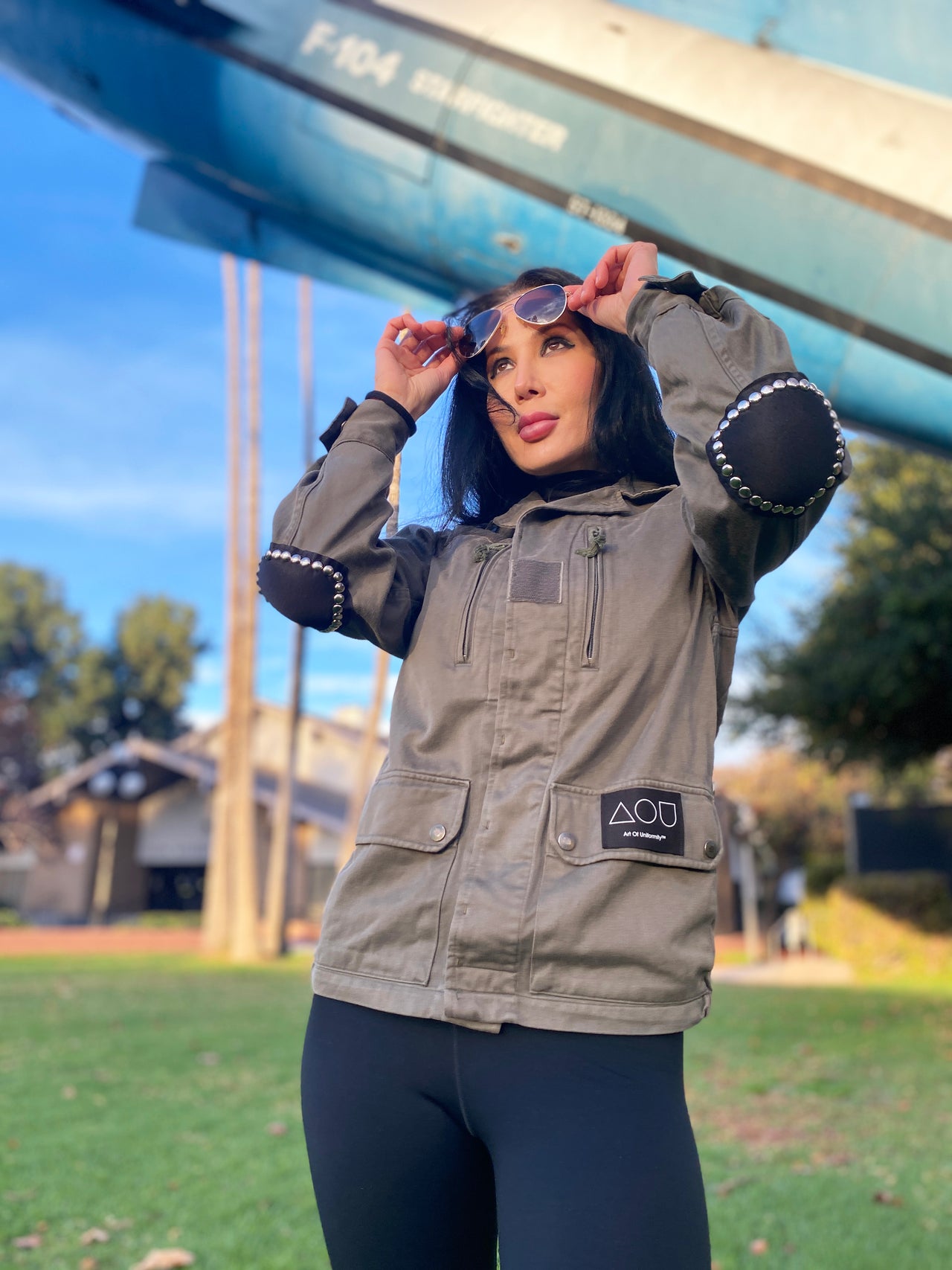 Model wearing a vintage French 80's bomber jacket featuring a studded black leather applique on the back and studded elbow pads.